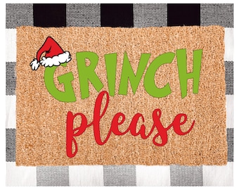 May include: A brown coir doormat with the text "GRINCH please" in green and red lettering. A red Santa hat with white trim is in the top left corner.