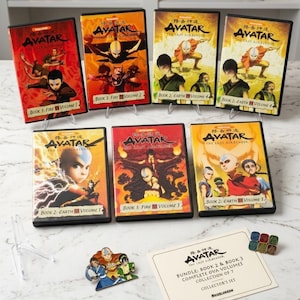 Puede incluir: Una colección de siete estuches de DVD de la serie animada Avatar: La leyenda de Aang. Los estuches son de varios colores, incluyendo rojo, naranja y amarillo, con ilustraciones de personajes. También se incluyen un pin y una tarjeta de coleccionista.