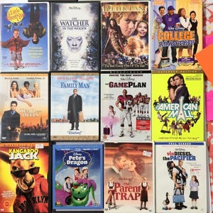 May include: A collection of DVDs featuring family movies and animated films. Titles include "The Lion, the Witch and the Wardrobe", "The Family Man", "The Game Plan", "The Parent Trap", and "Wall-E". The DVDs are in various colors and designs.