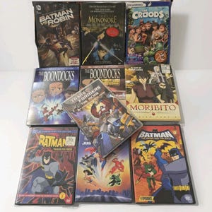 Op de afbeelding: Een verzameling dvd's met animatiefilms en tv-shows. Titels zijn onder meer "Batman vs Robin", "Prinses Mononoke", "The Croods", "The Boondocks", "Transformers: The Movie", "Moribito" en "Batman: The Brave and the Bold". De dvd's zitten in hun originele hoesjes.