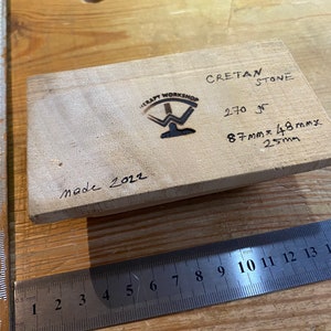 Peut inclure: Un bloc de bois avec le texte "Cretan Stone" et "270 gr" &eacute;crit dessus. Le bloc a &eacute;galement les dimensions "87mmx48mmx25mm" &eacute;crites dessus. Le bloc est marqu&eacute; "Made 2022" et porte le logo de "Therapy Workshop".