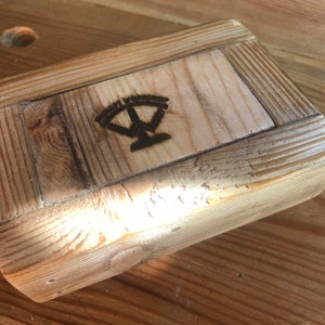 Puede incluir: Una caja de madera con un acabado natural y un logotipo quemado que dice "The Workshop".