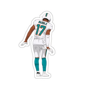 May include: A white football jersey with the number 17 and the name "Waddle" on the back. The jersey is worn by a player with teal and orange accents on the jersey and pants.