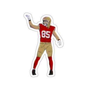 Könnte beinhalten: Ein Aufkleber mit einer Illustration eines Footballspielers in einem roten Trikot mit der Nummer 85, goldfarbenen Hosen und einem goldenen Helm. Der Spieler befindet sich in einer feierlichen Pose, mit einem Arm erhoben. Der Aufkleber hat einen weißen Rand.