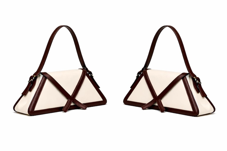 Peut inclure: Deux sacs &agrave; main cr&egrave;me avec un design triangulaire unique. Les sacs pr&eacute;sentent des bordures et des sangles marron fonc&eacute;, avec une seule poign&eacute;e. Les sacs ont une esth&eacute;tique minimaliste, adapt&eacute;e &agrave; diverses occasions.