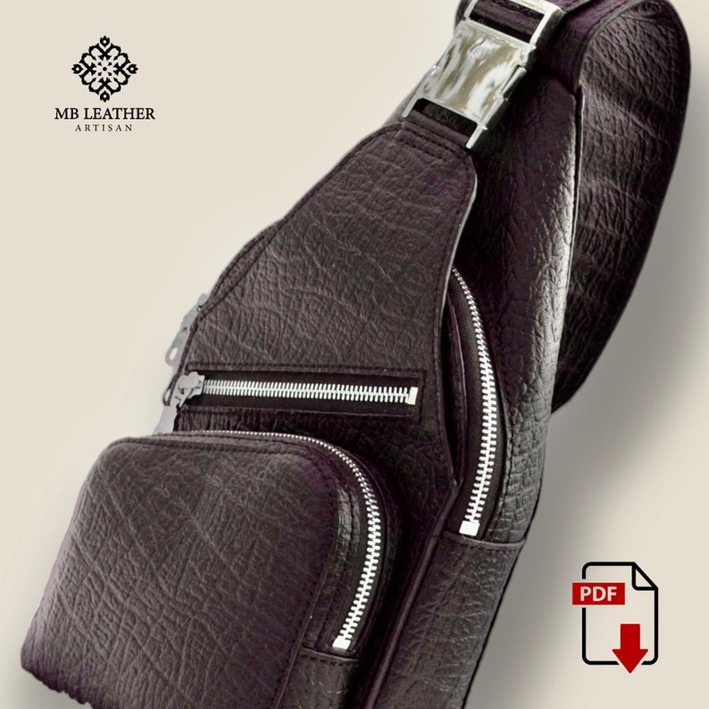 Peut inclure: Un sac &agrave; bandouli&egrave;re en cuir marron avec deux poches zipp&eacute;es et une boucle argent&eacute;e. Le sac est fabriqu&eacute; par MB Leather Artisan.