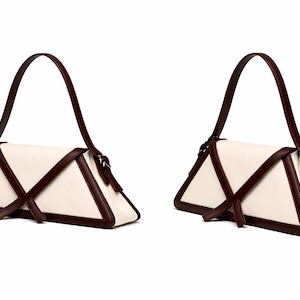 Peut inclure: Deux sacs &agrave; main cr&egrave;me avec un design triangulaire. Les sacs ont des bordures et des sangles marron fonc&eacute;. Les sangles sont arqu&eacute;es au-dessus du sac. Les sacs sont pr&eacute;sent&eacute;s sur un fond blanc.