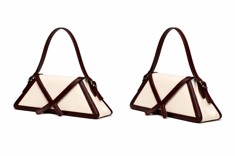 Peut inclure: Deux sacs &agrave; main cr&egrave;me avec un design triangulaire. Les sacs ont des bordures et des sangles marron fonc&eacute;. Les sangles sont arqu&eacute;es au-dessus du sac. Les sacs sont pr&eacute;sent&eacute;s sur un fond blanc.