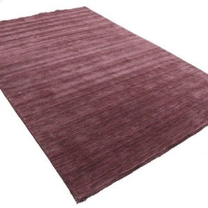 May include: A rectangular rug in a deep burgundy color. The rug has a textured, ribbed surface, with horizontal lines running across its length. The rug is set against a white background.
