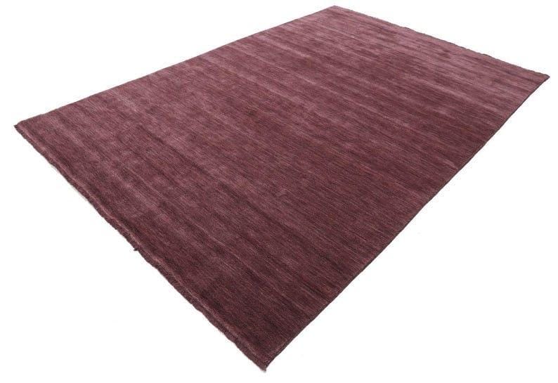 May include: A rectangular, plum-colored rug with a textured surface. The rug has a simple design with a solid color and a soft, inviting appearance. The rug is suitable for a living room or bedroom.