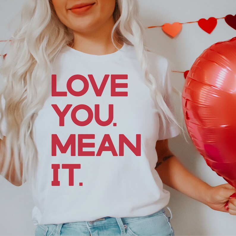 May include: White t-shirt with the text "LOVE YOU. MEAN IT." printed in red.