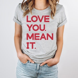 May include: A gray t-shirt with the text "LOVE YOU. MEAN IT." printed in red.