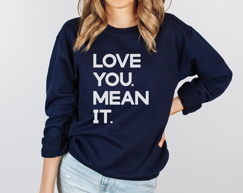 May include: A navy blue sweatshirt with the text "LOVE YOU. MEAN IT." printed in white.