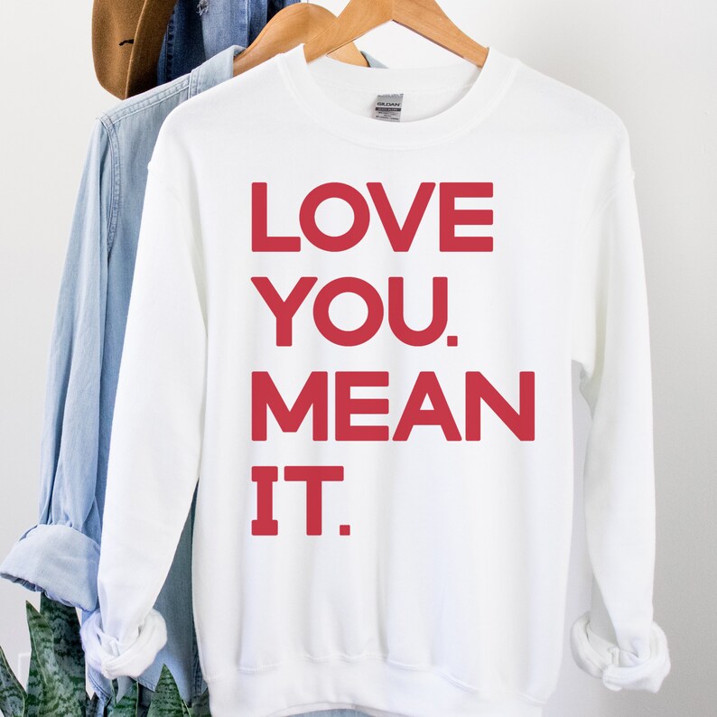 May include: White sweatshirt with red lettering that says "LOVE YOU. MEAN IT."