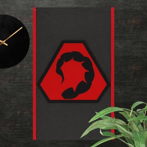 Könnte beinhalten: Ein schwarz-roter Wandbehang mit einem schwarzen Skorpion-Design in einem roten Sechseck. Der Hintergrund ist dunkelgrau mit einem dezenten diagonalen Muster. Ein roter Rand umrahmt das Design. Eine schwarze Uhr mit goldenen Zeigern ist sichtbar.