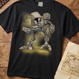 Pode incluir: Camiseta preta com uma ilustração de desenho animado de um robô. O robô tem um piloto esqueleto tocando música. O robô é cinza e tem o número "017" em um lado. Notas musicais flutuam acima do robô. A camiseta está em uma superfície de madeira.