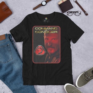 Könnte beinhalten: Schwarzes T-Shirt mit einer roten und goldenen Grafik eines Männergesichts und dem Text "COMMAND & CONQUER".