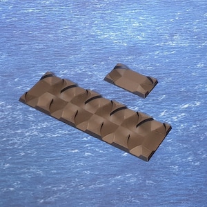 May include: Two brown chocolate bars with a textured surface. The larger bar is rectangular and has a pattern of raised squares. The smaller bar is square and has a similar pattern.