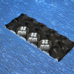 May include: A black plastic base with three circular inserts, each labelled "32 mm".