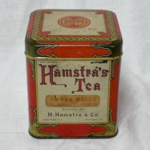 May include: Vintage Hamstra's Tea tin with a red and gold design. The rectangular tin features the text "Hamstra's Tea" in a decorative font, along with the text "24 Tea Balls, Net Weight 2 Ounces". The tin is packed by H. Hamstra & Co. in New York, N.Y. and Chicago, Ill.