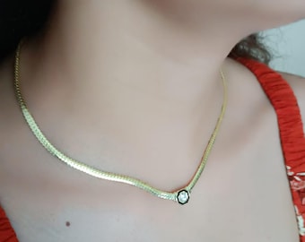 May include: A gold chain necklace with a single clear stone pendant.