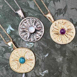 May include: Three celestial-themed pendant necklaces. One silver-toned necklace features a round pendant with a moonstone center. Two gold-toned necklaces have pendants with turquoise and amethyst centers. Each necklace has a delicate chain.