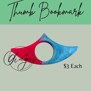 May include: A thumb bookmark with a red and blue glitter design. The bookmark has a circular opening for the thumb and is shaped to hold pages open. Text on the image reads "Thumb Bookmark" and "Ginger Quick Design".