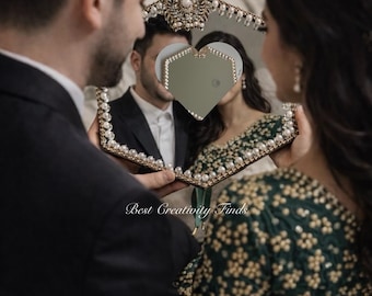 May include: A decorative mirror with a heart-shaped center, framed with pearls and ornate gold accents. The mirror reflects a couple, with the text "Best Creativity Finds" visible.
