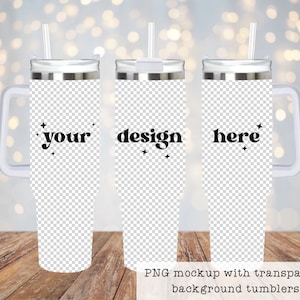 May include: Three stainless steel tumblers with a white handle and a straw. The tumblers are on a wooden surface. The tumblers have a transparent background and the text "your", "design", and "here" is printed on them.