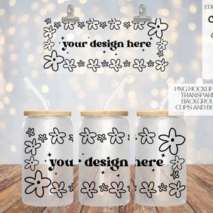 Puede incluir: Tres vasos de vidrio transparentes con tapas de madera y diseños florales negros. Los vasos tienen pajitas y el texto "you design here" está impreso en la parte delantera.