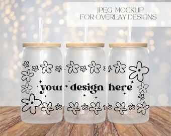 May include: Three clear glass tumblers with wooden lids and black straws. Each tumbler features a black floral design and the text "your design here" printed on the front.