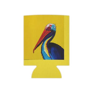 May include: Yellow drinks koozie with a painting of a pelican. The pelican has a long red beak, blue and black feathers, and a white head with blue accents. The koozie is made of a foam material.