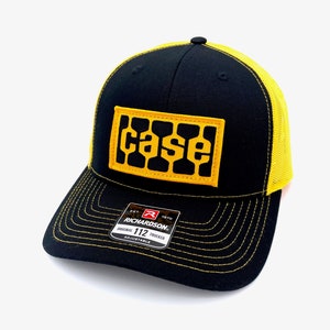 May include: Black and yellow trucker hat with a yellow "CASE" logo patch on the front. The hat is made by Richardson 112.