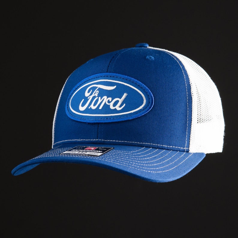 May include: A blue and white trucker hat with a white oval patch that says "Ford" in white lettering.