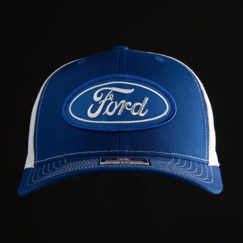 May include: A blue and white trucker hat with a white Ford logo on the front.