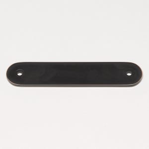 May include: A black metal rectangular door pull with rounded edges and two small holes.