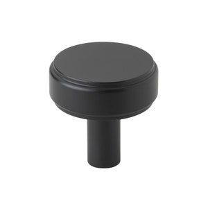 May include: Black cabinet knob with a round, flat top and a cylindrical base.