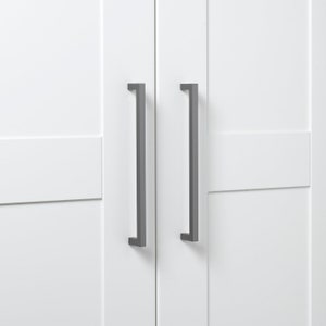 May include: Two white cabinet doors with black metal handles. The doors have a raised panel design.