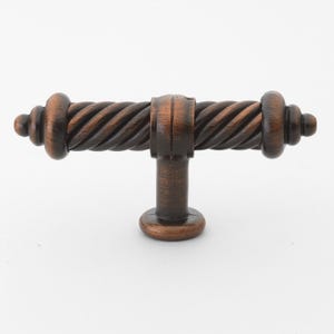 May include: A dark brown, twisted, metal cabinet knob with a T-shaped design.
