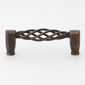 May include: A twisted, dark bronze cabinet pull with a decorative, woven design.