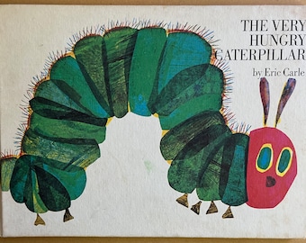 May include: The Very Hungry Caterpillar book cover features a green caterpillar with red and yellow spikes, and a red butterfly with blue eyes. The title "The Very Hungry Caterpillar" is printed in black text, and the author "by Eric Carle" is printed in smaller black text.