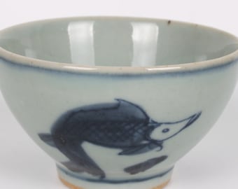 Może przedstawiać: Mała, jasnoniebieska ceramiczna miska z niebiesko-białym wzorem ryby. Miska ma lekko rozszerzający się brzeg i zaokrąglone dno.