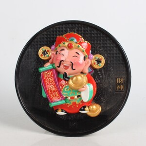 Hand-painted lacquerware on the face of the God of Wealth statue