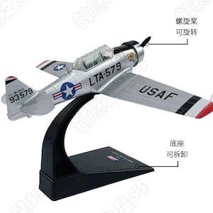 Könnte beinhalten: Ein silbernes Flugzeugmodell mit schwarzem Propeller, klarer Cockpithaube und USAF-Markierungen. Der Rumpf trägt die Aufschrift LTA-579 und 93579. Es ist auf einem schwarzen Ständer montiert. Der Propeller ist drehbar und der Sockel abnehmbar.