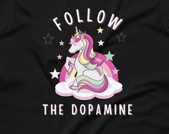 May include: Black t-shirt with a pink and white unicorn sitting on a cloud with stars and the text "FOLLOW THE DOPAMINE".