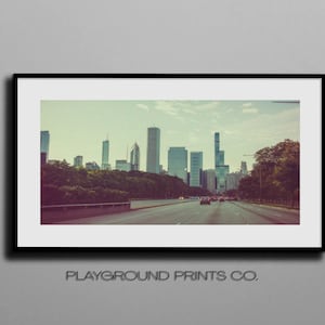 Könnte beinhalten: Ein Vintage-Foto der Skyline von Chicago mit hohen Gebäuden und einer Autobahn mit fahrenden Autos.