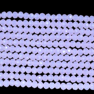 May include: A strand of pale lavender faceted glass beads. The beads are round and have a smooth, polished finish.