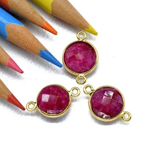 Puede incluir: Tres conectores de piedras redondas de color dorado con piedras de rubí rojo facetadas. Cada conector tiene dos bucles para sujetar a las joyas.