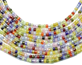 May include: A strand of colorful gemstone beads, featuring shades of blue, green, yellow, pink, and red. The beads are faceted and have a slightly irregular shape.