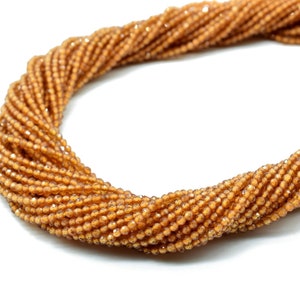Peut inclure: Un brin de petites perles de verre facettées de couleur ambre. Les perles sont enfilées sur un fil transparent.